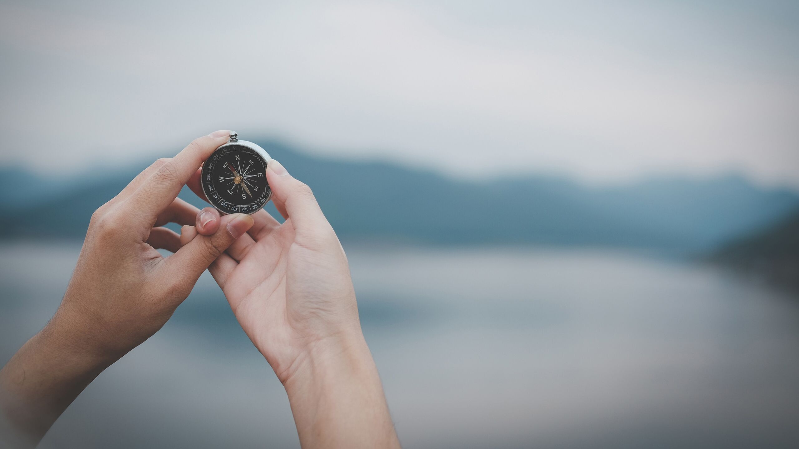 Zwei Hände halten einen Kompass. Die unabhängige Vermögensverwaltung Dagg Invest